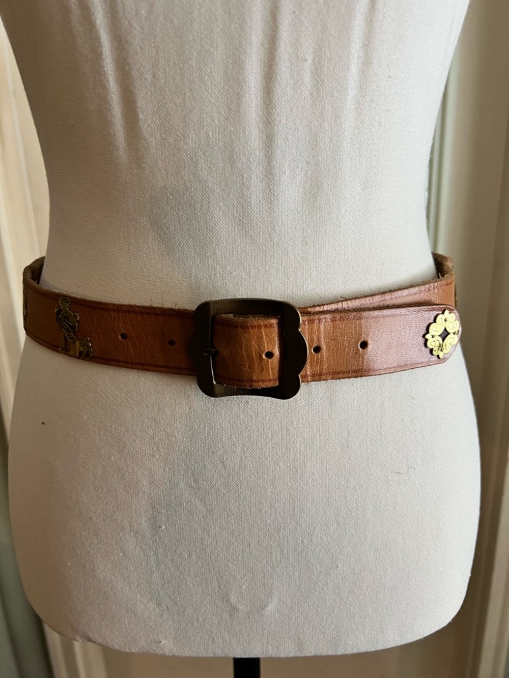 Vintage light camel colored leather belt with bronze tone buckle brass figures